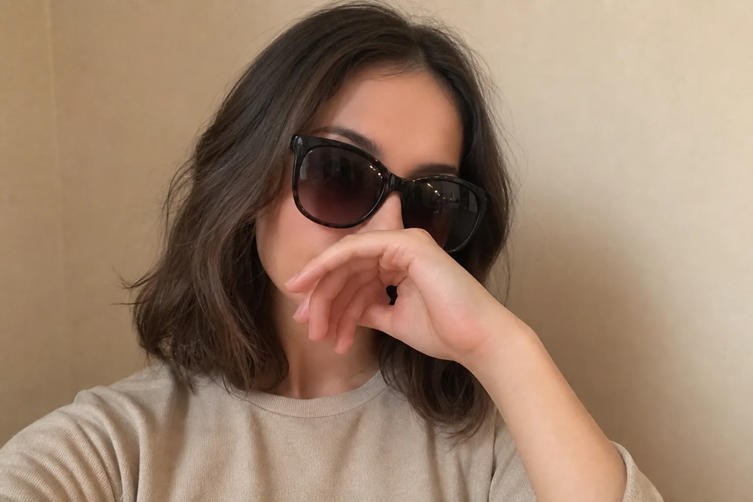 Portrait with sunglasses and a hand covering facial features